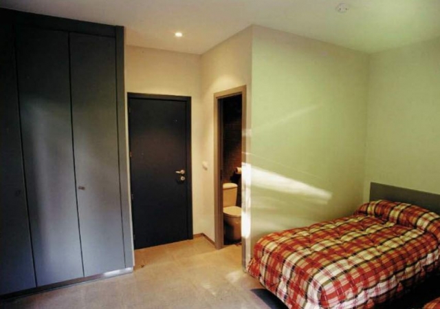  room with two beds, a closet and a bathroom in the background 